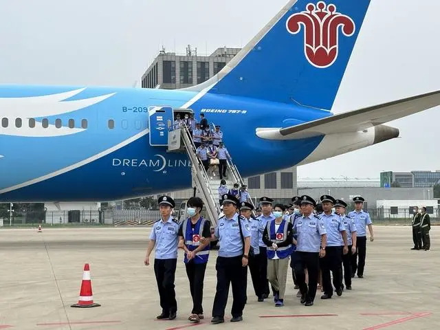 民警在郑州新郑国际机场押解犯罪嫌疑人下飞机
